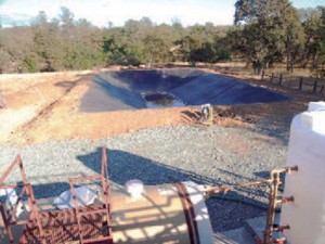 Wide view of an excavated pond for treating wastewater