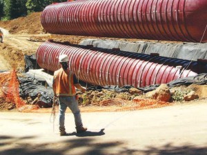 A worker supervises the installation of a 40,000 gallon wastewater tank
