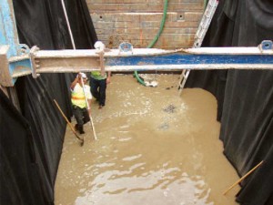 Workers installing a wastewater system in an excavation pit
